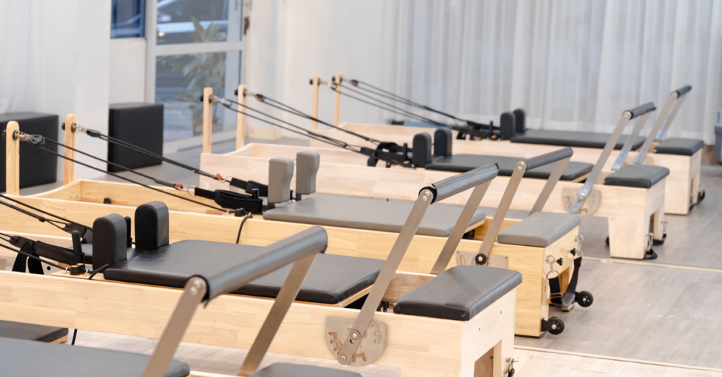 A contemporary Pilates studio equipped with multiple wooden reformers for fitness training.