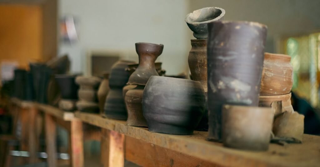 A collection of rustic pottery displayed on a wooden shelf, capturing the artisanal charm of handmade ceramics.