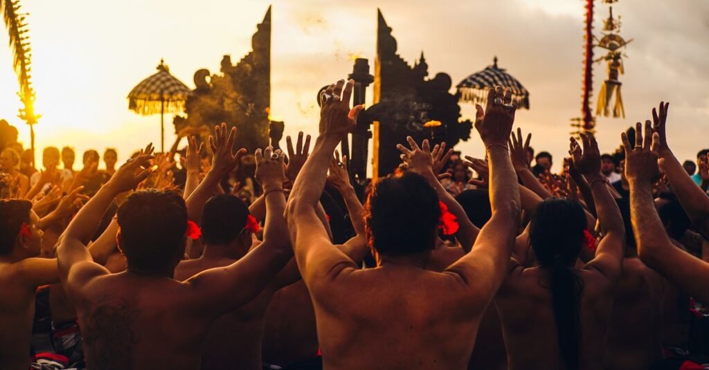 Peserta merangkul budaya Bali saat menari Kecak saat matahari terbenam di Bali, Indonesia.