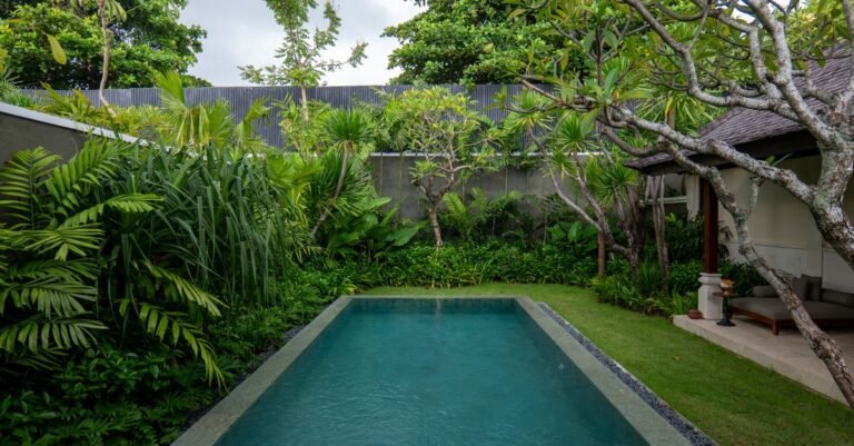 Luxurious villa pool surrounded by lush tropical greenery in Bali, Indonesia.