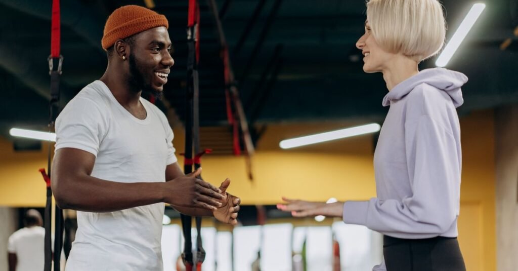 Two fitness trainers conversing indoors, fostering a healthy and active lifestyle.