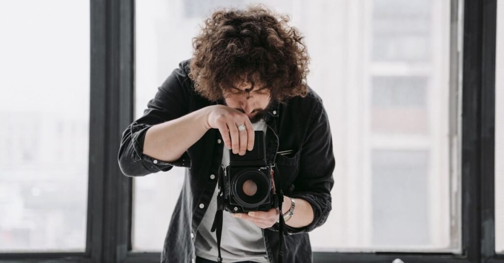 Man photographing with vintage camera in a bright, modern indoor setting.